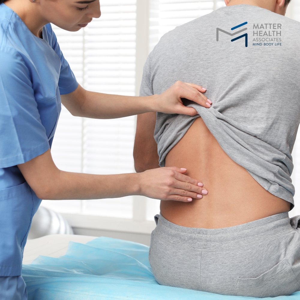 Decoding Pain Why Understanding the Cause is Key to Healing | Therapist assessing patient’s back pain during consultation to determine personalized pain management strategy at MHA clinic.