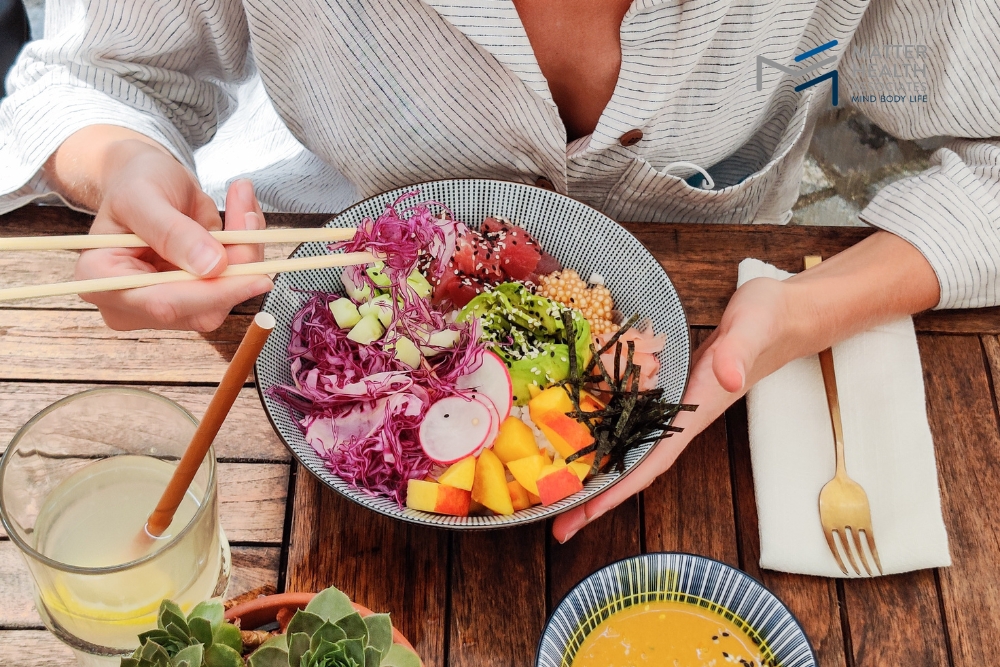 Eat with Intention: Let Your Body Guide Your Food Choices | Close-up of hands gently holding a colorful salad bowl, symbolizing mindful eating, self-care, and intuitive food choices based on the body’s natural needs.
