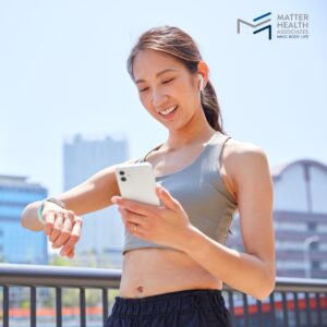 How to Understand the Good and Bad of Exercise and Nutrition Technology | Person using fitness tracking app on smartphone while taking a break during an outdoor workout, representing the blend of technology and mindful exercise habits.
