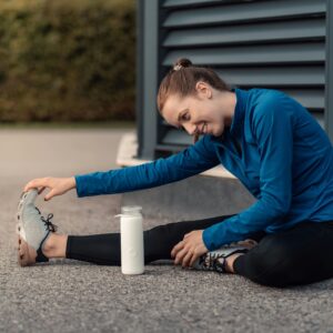 Young woman happily stretching outdoors as part of an effective exercise program guided by personal training