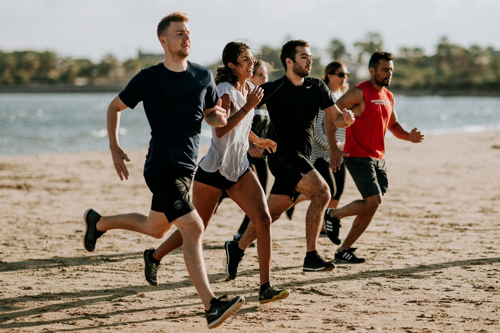 Group of people having fun while running together, showing that an effective exercise can also be enjoyable and social.