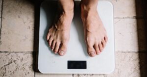 Feet on a digital scale representing the common obsession with numbers in health and nutrition.