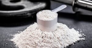 A measured scoop of white creatine powder representing common supplementation in fitness.