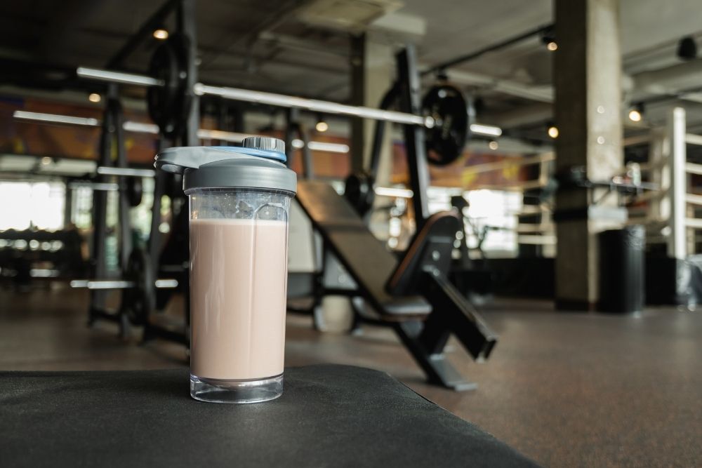 A protein powder shake in a gym setting, representing the common but overused foundation of many modern diets.