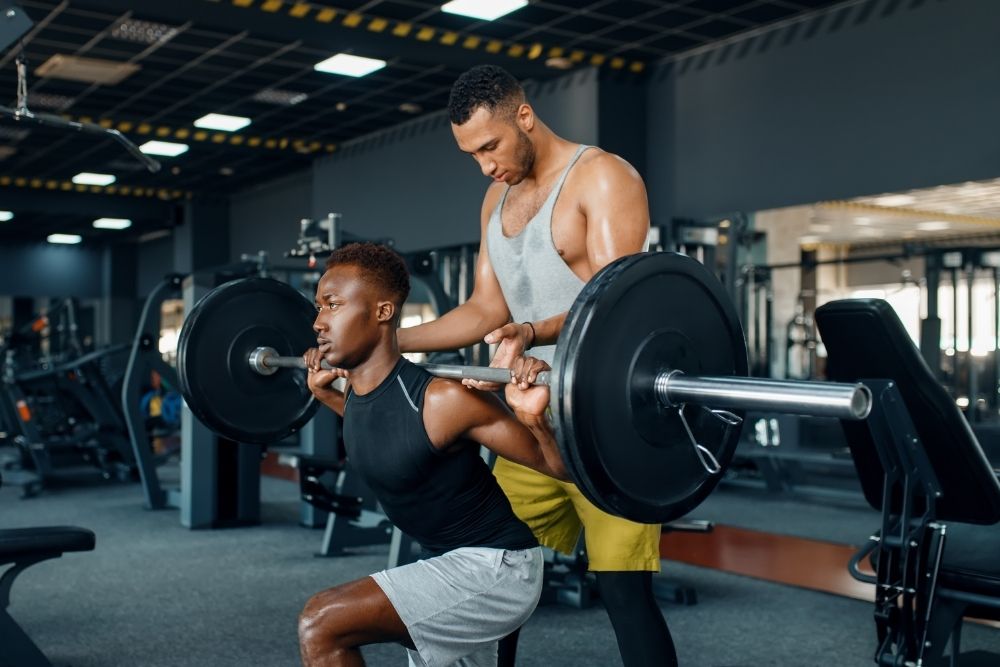 two men working out together in a gym, demonstrating the growth mindset in fitness through the sheepdog mentality.