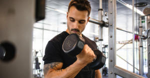 A dedicated man working out in a gym, illustrating the power of a growth mindset in fitness over trophies.