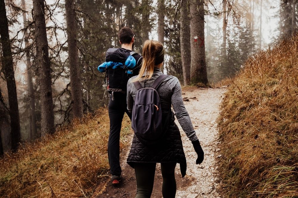 A man and a woman hiking as part of their sustainable fitness journey