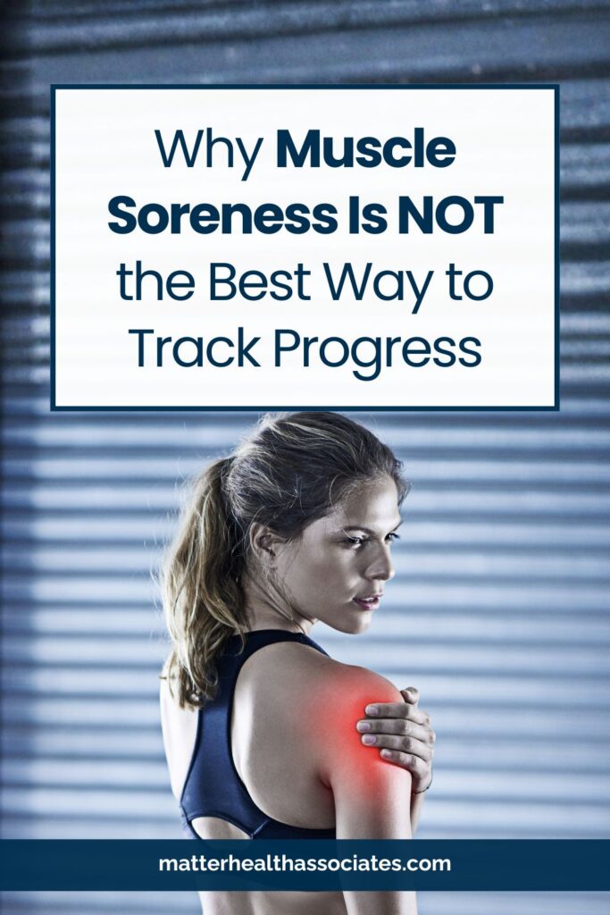 A woman in gym clothes massaging her shoulder with an expression of discomfort, featuring the text overlay: "Why Muscle Soreness Is NOT the Best Way to Track Progress."