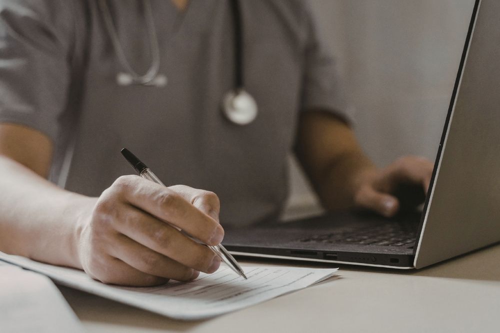 Healthcare professional writing notes to discuss GLP-1s and resistance training management with patients