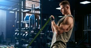 Man exercising with resistance bands in a gym setting, highlighting the importance of GLP-1s and resistance training for muscle retention