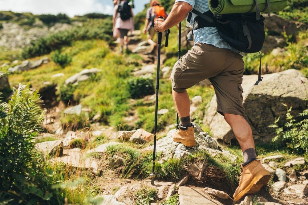 A hiker navigating a rugged mountain trail as part of the Hunter Athlete System outdoor conditioning approach.
