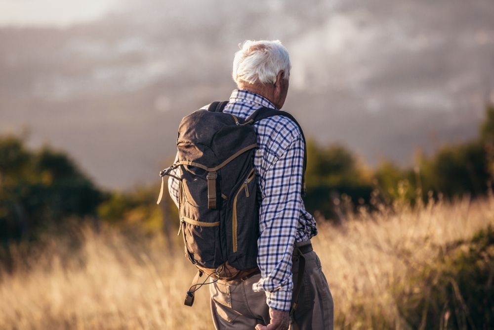 An active older adult hiking with a backpack, proving age is no barrier within the Hunter Athlete System framework.