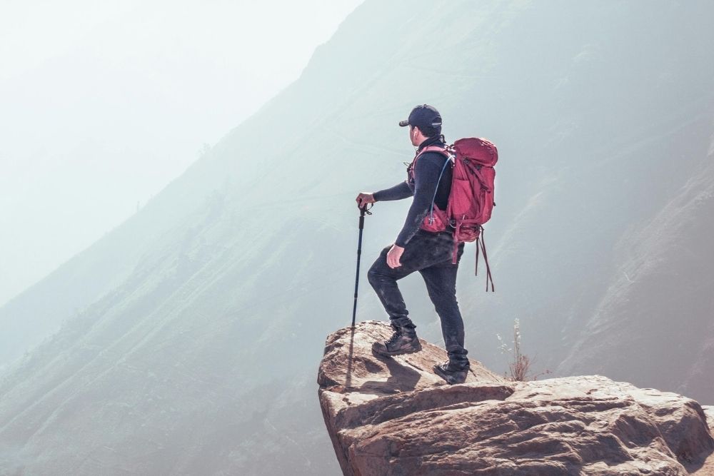 An outdoorsman looking over a mountain valley during a wilderness expedition.