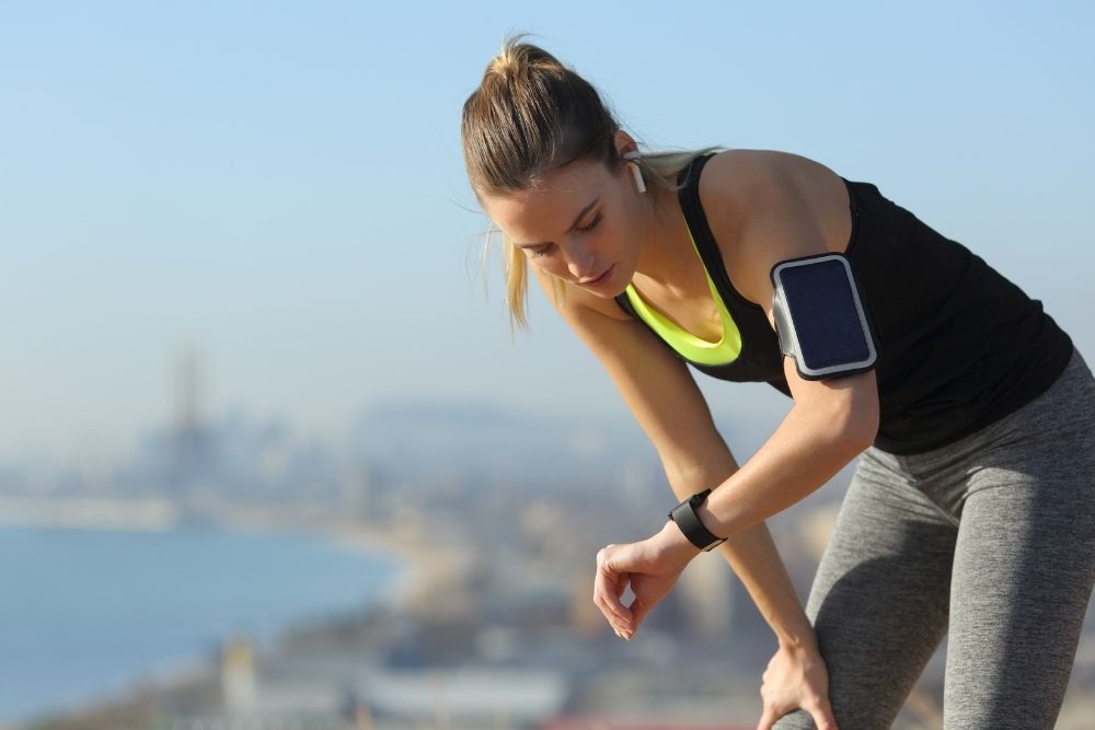 An athlete checking metrics on a smartwatch to train smarter throughout the seasonal training cycle.