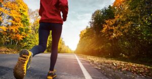 A runner training on an outdoor trail during the transitional season, representing the seasonal training cycle.